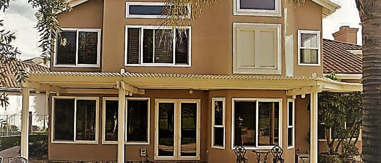 Two-storey stucco home with replacement windows across the rear elevation