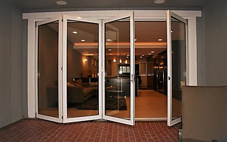 Bi-fold folding glass doors folded open onto a brick patio