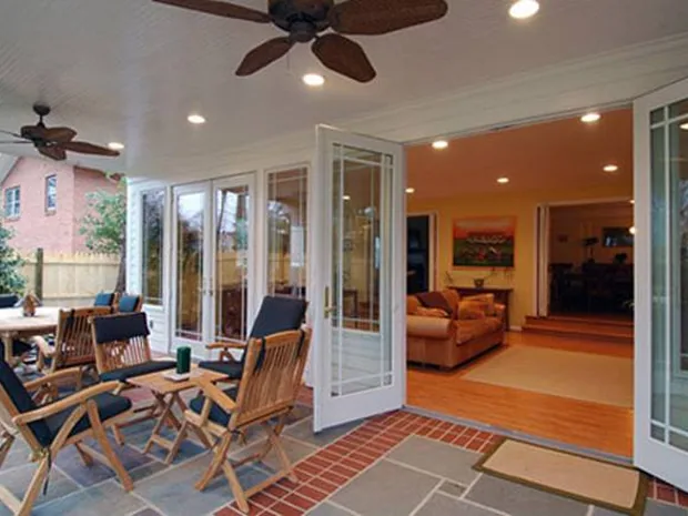 French patio doors open onto a brick patio with outdoor seating