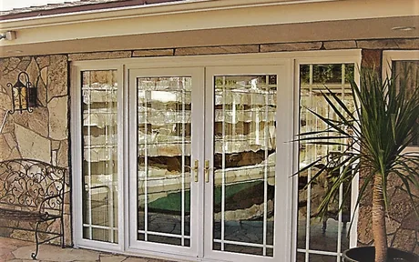 French sliding patio doors with sidelites set into a stone wall
