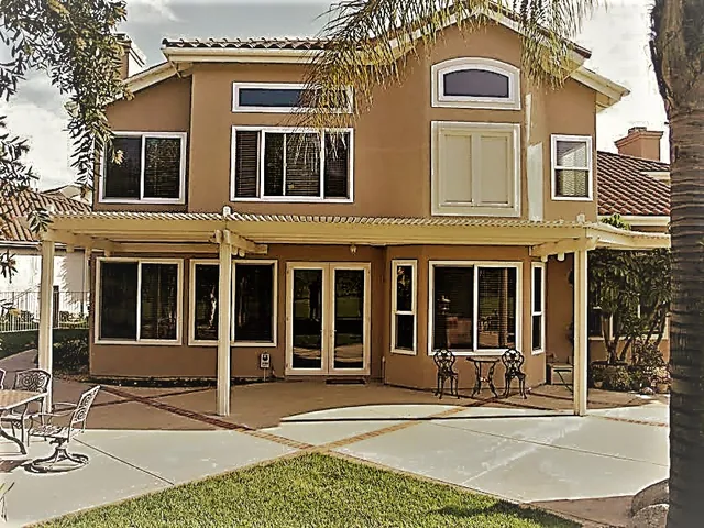 Two-storey stucco home with replacement windows to the rear