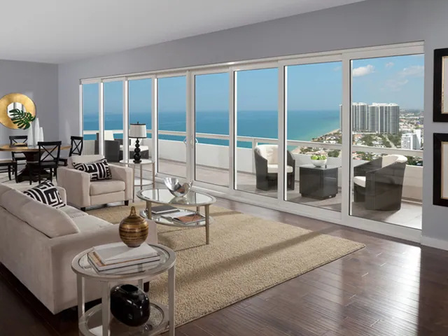 Living room opening to a coastal view through a multi-slide wall