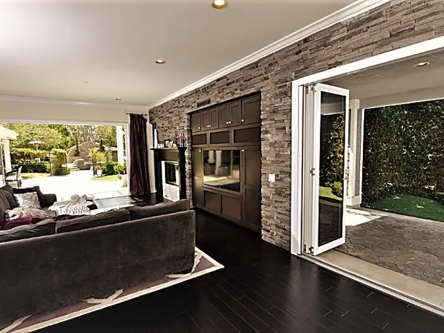 Living room with a folding door system in a stone feature wall