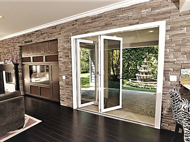 Stone wall opening framed by a folding door system
