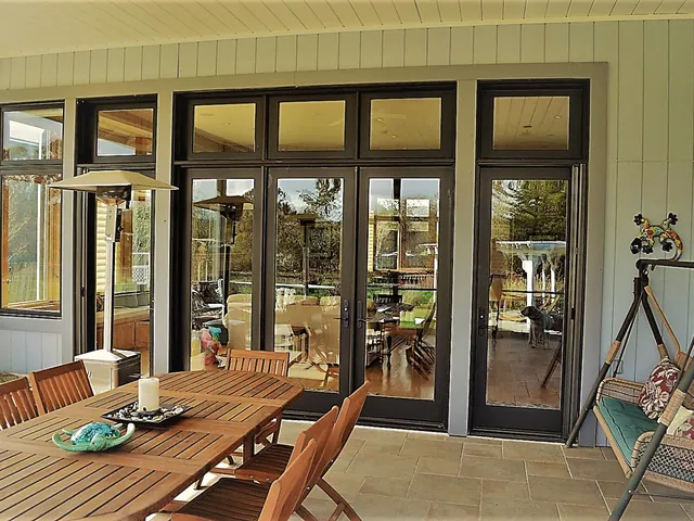 Bronze-framed folding doors onto a dining terrace