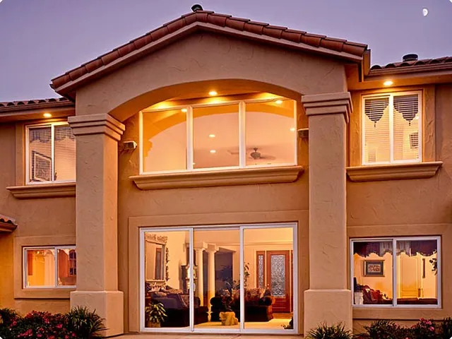 Spanish-style elevation lit at dusk through new windows