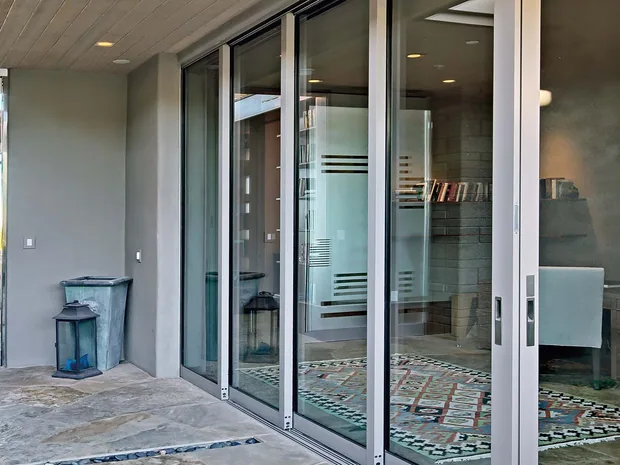 Wide multi-slide glass wall along a coastal living space