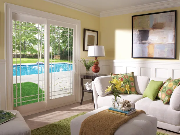 Living room with a wide window looking onto a pool